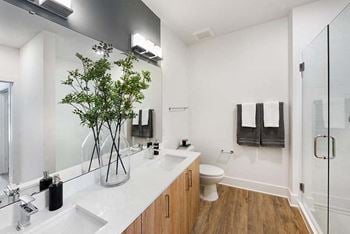 Relaxing bathrooms feature glass shower enclosures, subway tile showers and tubs, double vanity sinks, and modern matte black/chrome fixtures and hardware